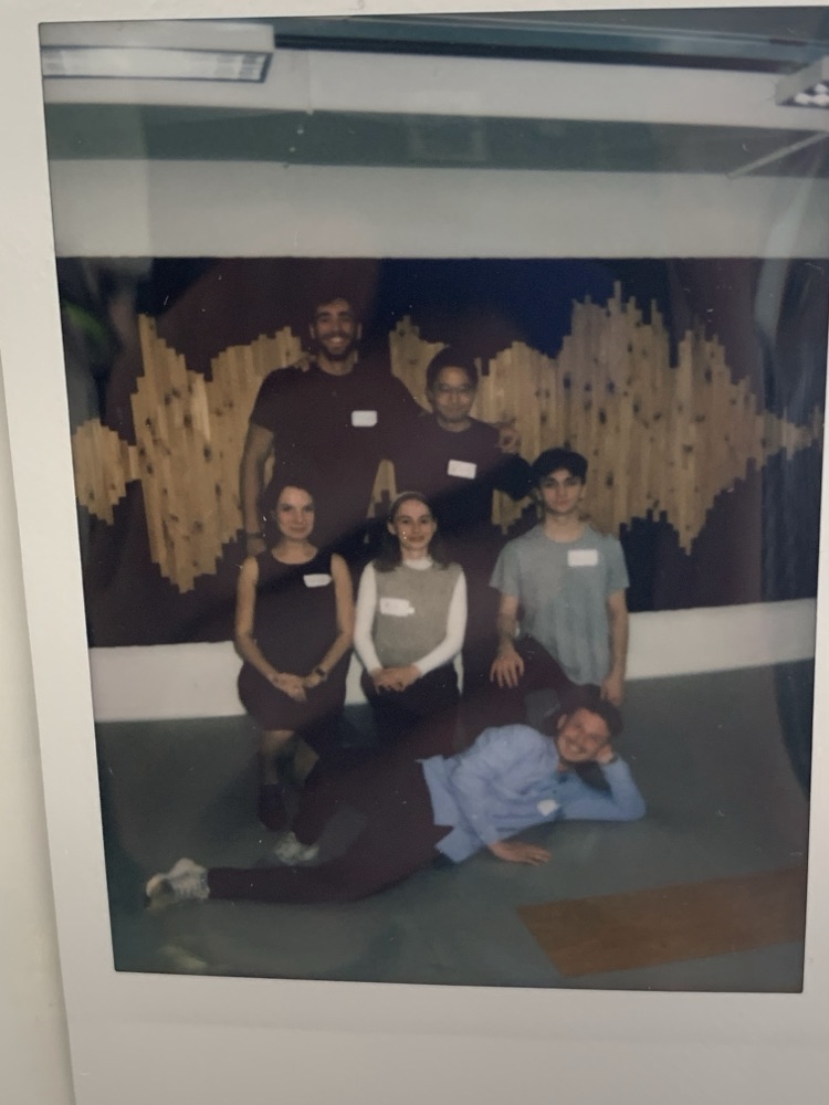 the team in front of the wood sound wave wall